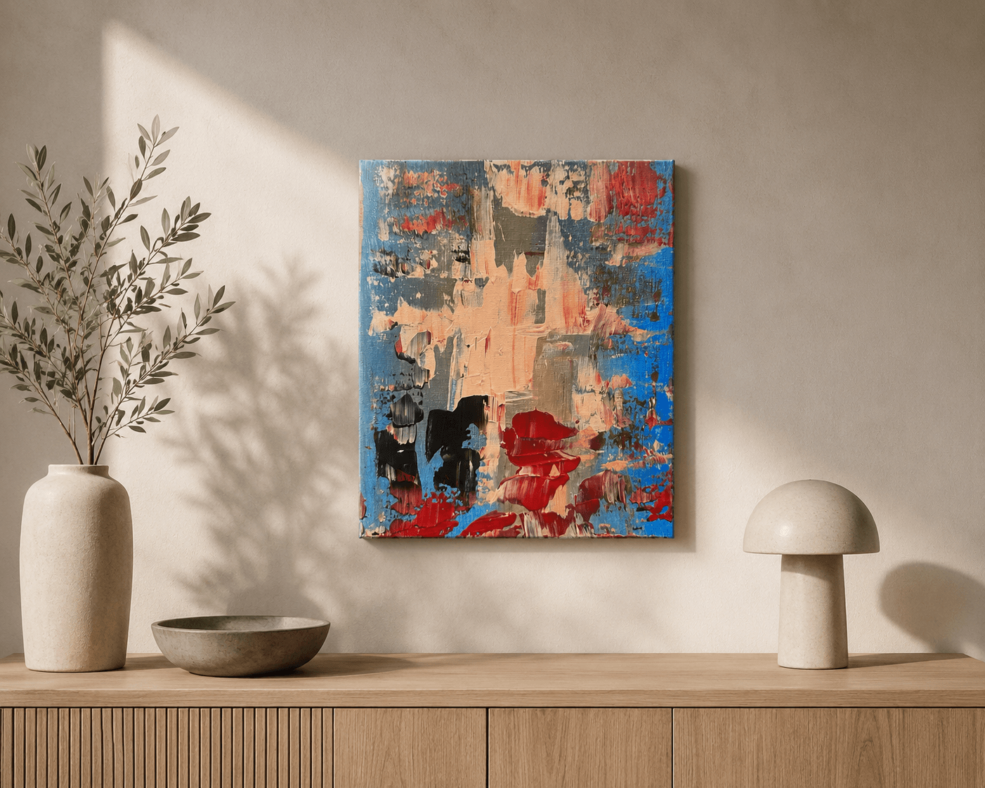 Undertow, a small blue, cream, red, and black abstract painting by Julia Mindar, shown on a wall