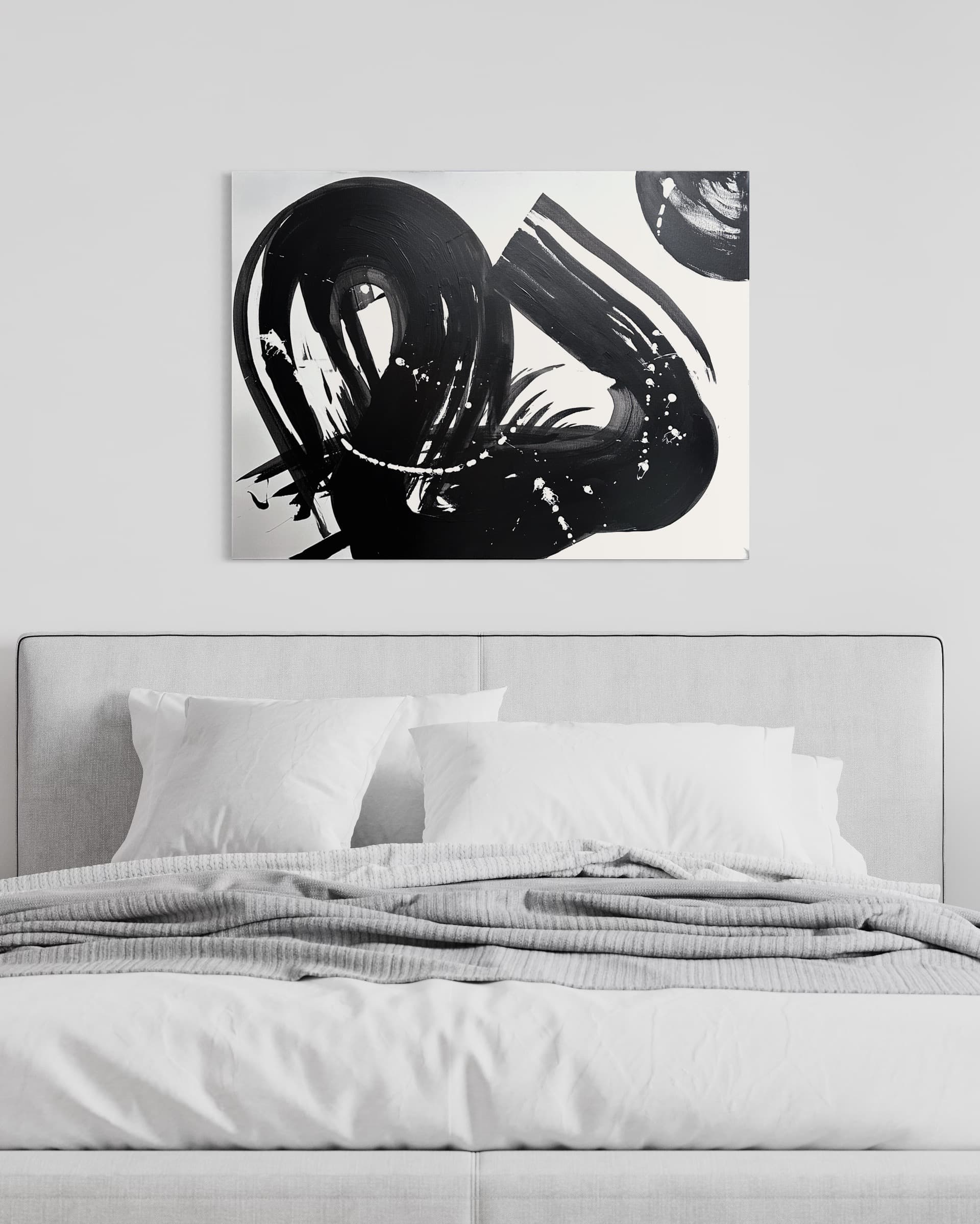 Swan, a black and white gestural abstract painting by Julia Mindar, shown above a bed